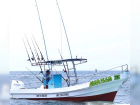 A fishing boat named 'Marissa III' is seen underway, equipped with multiple fishing rods, showcasing its readiness for a day on the water.