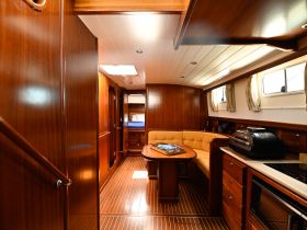 A beautifully designed interior of a boat featuring a cozy seating area and modern amenities, perfect for relaxing during a voyage.