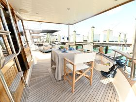 A beautifully arranged dining area on a yacht, featuring elegant seating and a table set for a meal, perfect for enjoying meals while cruising.