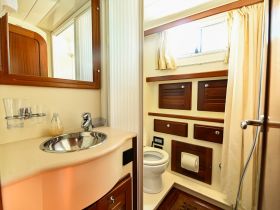 A well-appointed boat bathroom featuring a sink, mirror, and storage, showcasing the comfort and functionality of onboard living spaces.