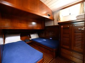 Interior view of a cozy boat cabin featuring twin beds and wooden finishes, perfect for comfortable overnight stays on the water.