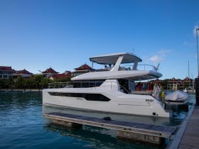 A luxurious yacht named Akula docked at a marina, with a lively group of guests preparing for an exciting day on the water.