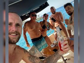 A lively group enjoys drinks and camaraderie aboard a boat, capturing the essence of a fun-filled day on the water.