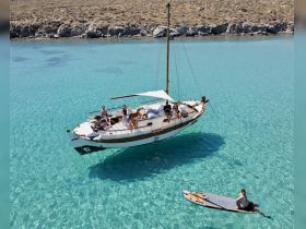 A lively group enjoys a day on a sailboat in crystal-clear waters, perfect for relaxation and adventure on the high seas.
