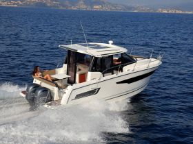 A woman relaxes on the deck of a sleek motorboat as it glides through the water, showcasing the perfect blend of luxury and adventure on the open sea.