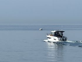 A sleek speedboat glides through calm waters, showcasing its elegant design and performance — perfect for leisurely outings on the water.