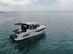 A sleek yacht named 'Sea la Vie' glides through calm waters, showcasing its elegant design and perfect for leisurely cruises.