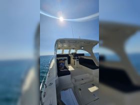 Interior view of a spacious boat cabin featuring comfortable seating and a helm, perfect for relaxing on the water.