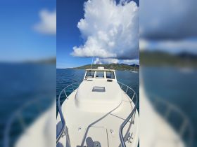 A clear view of the front deck of a boat, showcasing its sleek design against a backdrop of blue skies and calm waters, perfect for a day out on the sea.