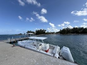 A sleek speedboat docked at a pier, surrounded by clear waters and a picturesque sky — perfect for exploring coastal destinations.