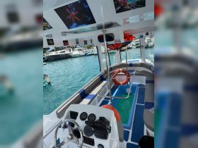 A well-equipped interior view of a boat's helm and seating area, showcasing a comfortable space for passengers and crew, perfect for enjoying a day on the water.