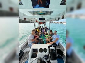 A lively group enjoys drinks aboard a boat, creating a festive atmosphere on the water — perfect for celebrations and outings with friends.