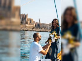 A romantic proposal takes place on a boat, with a couple celebrating their love against a picturesque backdrop. Perfect for memorable moments on the water.