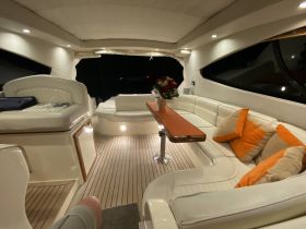 A cozy interior view of a boat's lounge area featuring comfortable seating and elegant decor, perfect for relaxing during a night cruise.