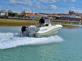A sleek Quicksilver speedboat glides through clear waters, showcasing its dynamic design and performance while underway.