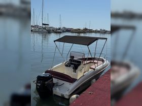 A sleek speedboat docked at the marina, showcasing its stylish design and comfortable seating, perfect for a day on the water.