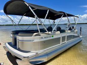 A sleek pontoon boat docked in calm waters, showcasing its spacious design and comfortable seating, perfect for leisurely outings on the water.
