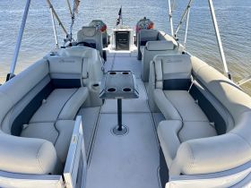 Interior view of a spacious pontoon boat featuring comfortable seating and a sleek design, perfect for relaxing on the water.