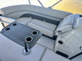 A cozy seating area inside a boat, featuring a stylish table with cup holders — perfect for relaxing and enjoying time on the water.