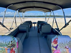 A spacious interior view of a pontoon boat featuring comfortable seating and a helm, perfect for relaxing on the water.