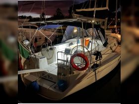 An illuminated view of the interior helm of the 'Blue Note' boat, showcasing its well-equipped console and cozy cabin space, perfect for evening outings.