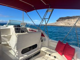A well-appointed helm area of a boat featuring comfortable seating and a clear view of the water, perfect for navigating scenic coastal routes.