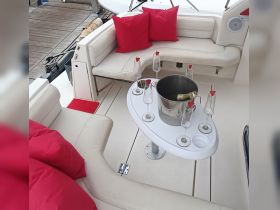 A stylish seating area on a boat featuring a champagne bucket and glasses, perfect for enjoying drinks while cruising.