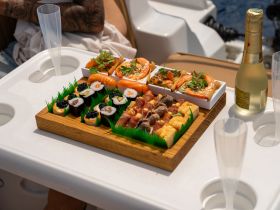 An exquisite spread of sushi and seafood delicacies served on a boat, perfect for enjoying gourmet meals while cruising on the water.