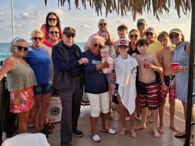 A joyful family gathering on a boat, capturing smiles and togetherness against a beautiful ocean backdrop — perfect for memorable celebrations.