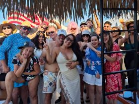 A lively group of friends celebrates together on a boat, showcasing joy and camaraderie in a fun-filled atmosphere.
