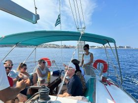 A lively group enjoys a sailing experience on a yacht, sharing laughs and drinks under the sun — perfect for memorable outings on the water.