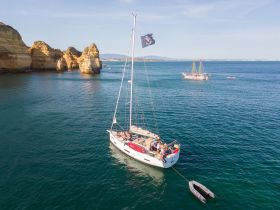 A picturesque sailing scene featuring a yacht navigating near stunning coastal rock formations, perfect for exploring the beautiful waters.