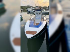 A sleek speedboat docked at the marina, showcasing its stylish design and spacious seating, perfect for fishing and leisure trips.