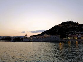 A serene sunset view over a picturesque harbor, showcasing the beautiful coastline and reflections on the water — perfect for capturing the essence of coastal adventures.