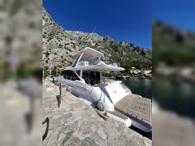 A stunning Azimut yacht docked at a picturesque marina, surrounded by majestic mountains — perfect for luxury charters and scenic getaways.