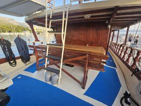 Interior view of a boat showcasing the seating area and helm, designed for comfort and functionality during voyages.
