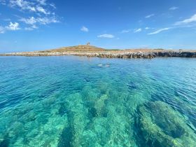 Two snorkelers explore the crystal-clear waters near an island, showcasing the beauty of underwater adventures and scenic landscapes.