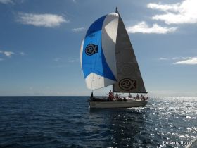 A lively group sails on a vibrant sailboat, enjoying the open water and sunny skies — a perfect day for adventure on the sea.