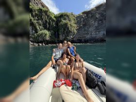 A lively group enjoys a day on the water, relaxing on a boat surrounded by stunning natural scenery — perfect for summer adventures and memorable outings.