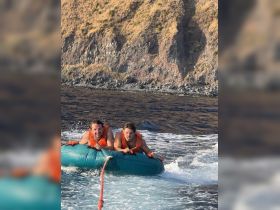 Two friends enjoy an exhilarating tubing experience on the water, showcasing the thrill of adventure and fun in the sun.