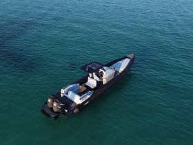 Aerial view of a sleek speedboat gliding through clear waters, showcasing its modern design and spacious layout — perfect for thrilling adventures on the open sea.