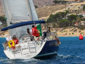 A lively group enjoys a sailing adventure on a beautiful day in Funchal, showcasing the joy of being on the water with friends.