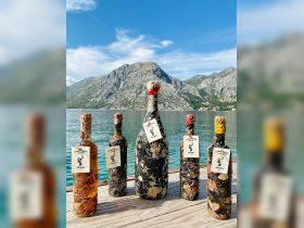 A collection of unique bottles from the Underwater Cellar, showcasing the Kraken brand, set against a stunning mountain backdrop — perfect for wine enthusiasts and underwater adventure lovers.