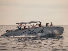 A lively group enjoys a fun day on the water aboard the 'Charlie' boat, showcasing the joy of on-water activities and celebrations.
