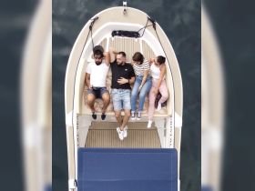 A group of friends relaxes on the deck of a boat, enjoying their time together on the water — perfect for social outings and memorable experiences.