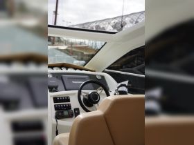 A detailed view of the helm and seating area inside a modern boat, showcasing the sleek design and advanced navigation equipment.