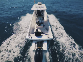 Aerial view of a speedboat cruising through sparkling blue waters, showcasing the vessel's sleek design and dynamic movement.