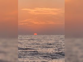 A stunning sunset over the ocean, creating a picturesque backdrop for any boating adventure.