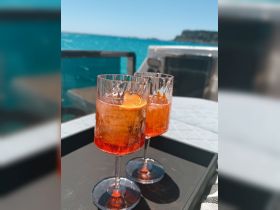 Two refreshing cocktails sit on a tray aboard a boat, perfect for enjoying the sun and sea. Ideal for a relaxing day on the water.