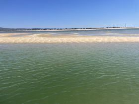 A scenic view of a sandy area surrounded by water, but the image lacks clarity and detail.